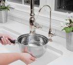 Woman Filling Pot with Water from Filter