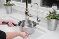 Woman Filling Pot with Water from Filter