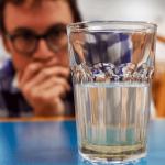 Man looking at water sediments