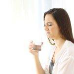 lady frowning at a glass of water