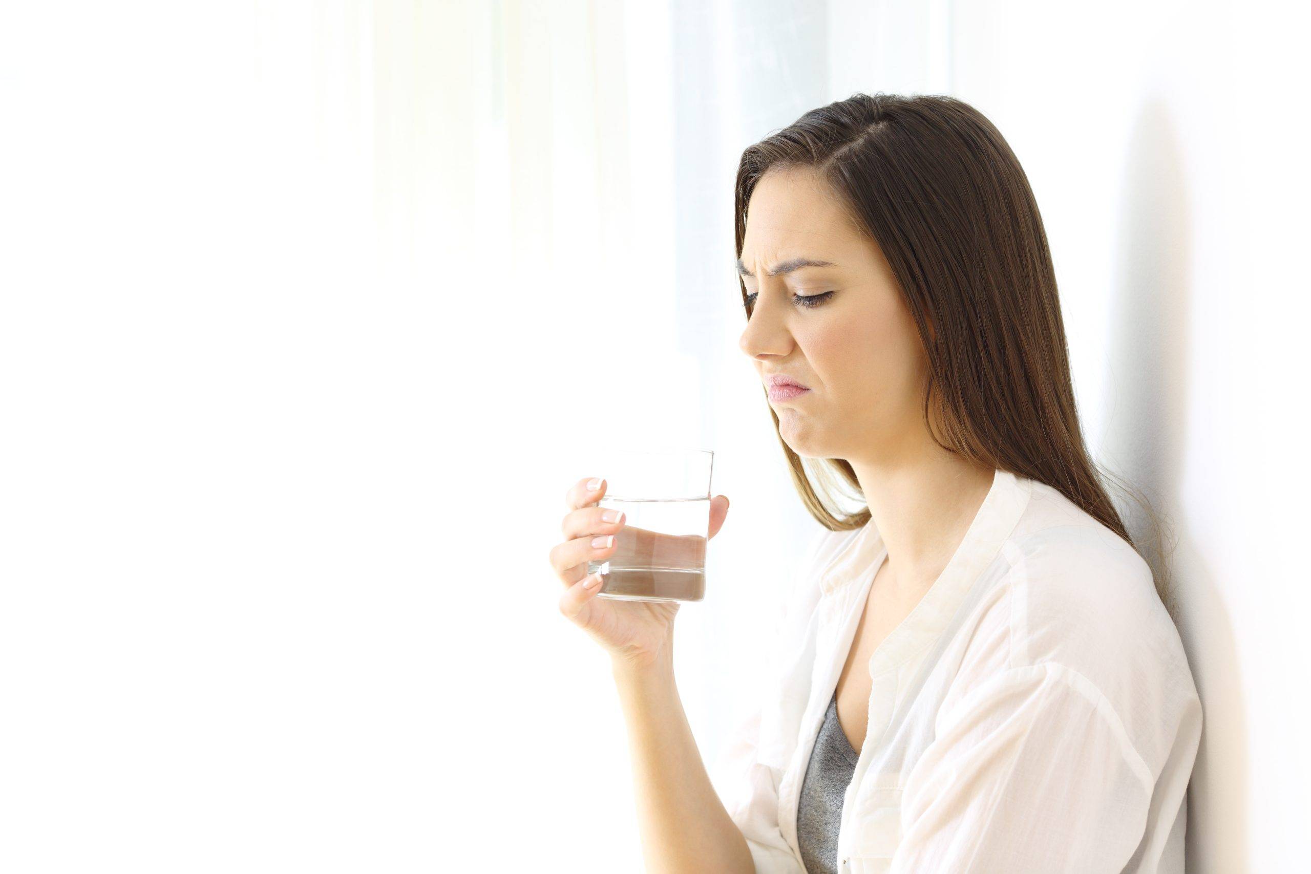 lady frowning at a glass of water